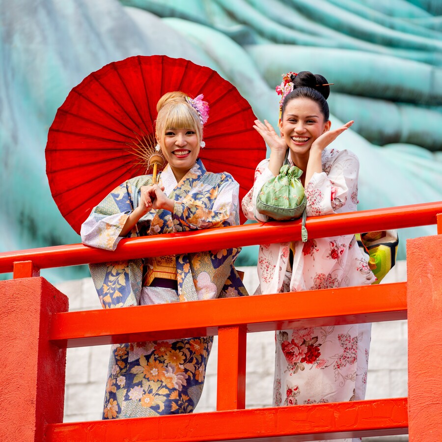 two-asian-pretty-women-stay-close-to-red-railing-i-8WNGWNE.jpg